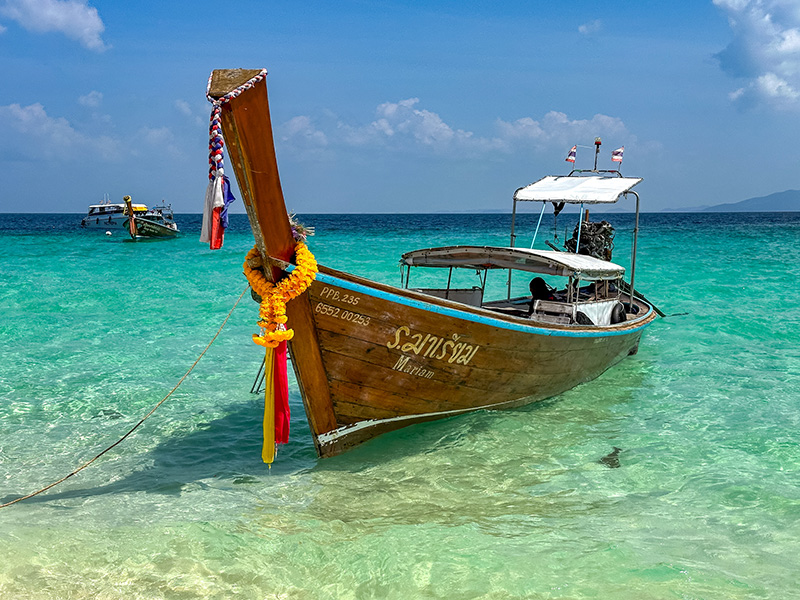 A longtail boat sits in the stunning turquoise waters on Koh Phi Phi, Thailand
